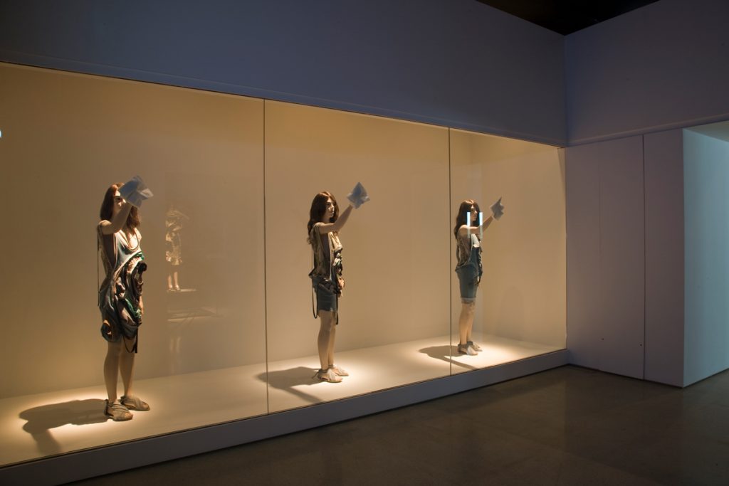 Exhibition display of three dressed mannequins
