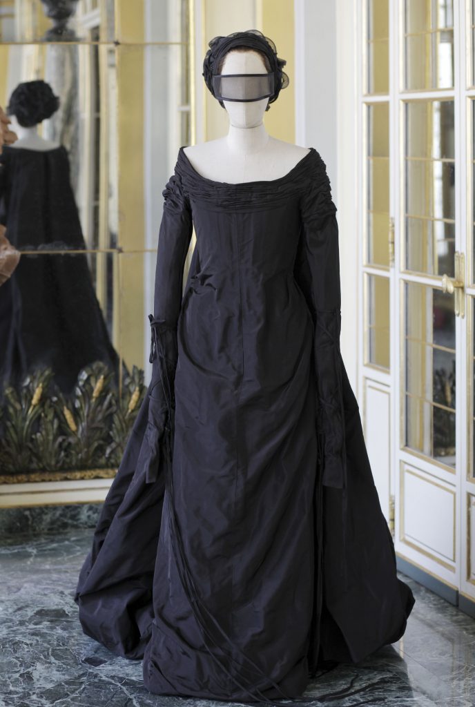 mannequin in dark long dress and masked eyewear