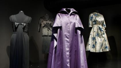 Exhibition display of dressed mannequin in purple satin robe