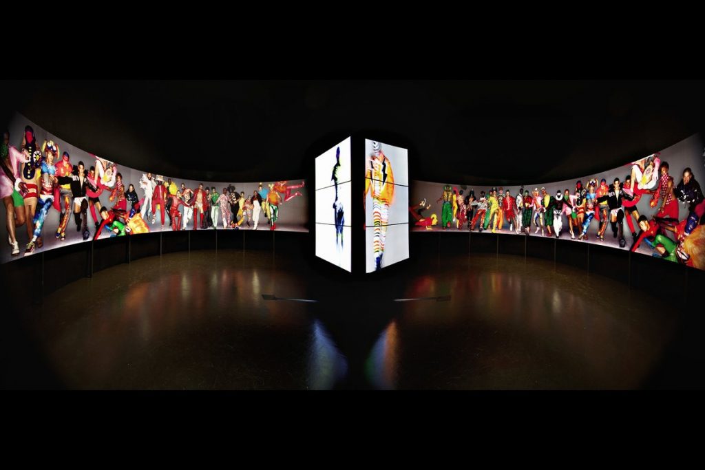 Exhibition display of a semi circular digital banner of models in pose