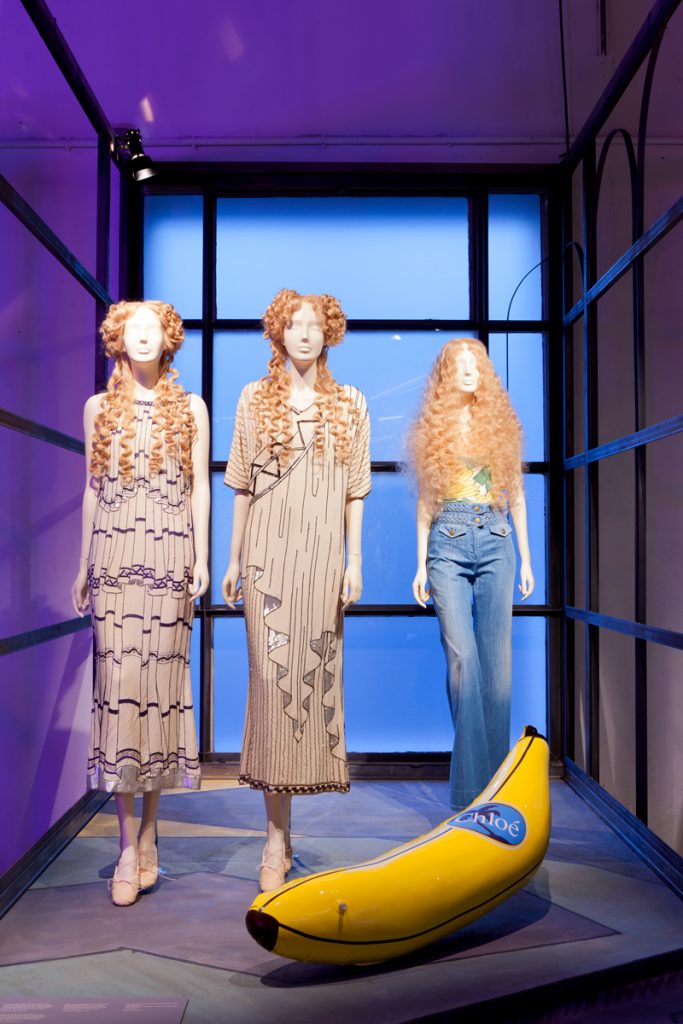 Exhibition display of three dressed mannequins with blow up banana in foreground