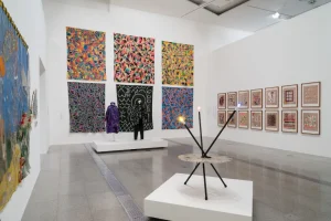 gallery view of sculptural installation with a backdrop of abstract images on the wall