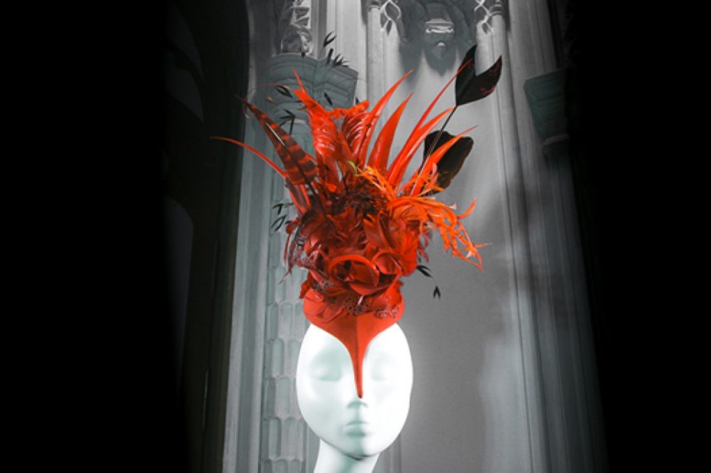 Exhibition display of red headdress on mannequin head