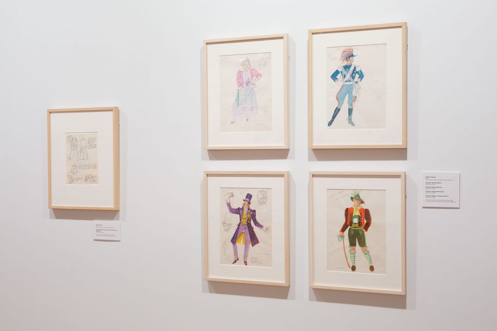 Five costume illustrations depicting menswear in hues of purple, green, yellow and blue.