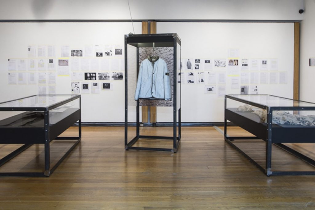 Exhibition display of glass cases containing garments