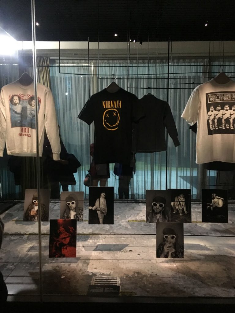 Exhibition display of t-shirts among record sleeves
