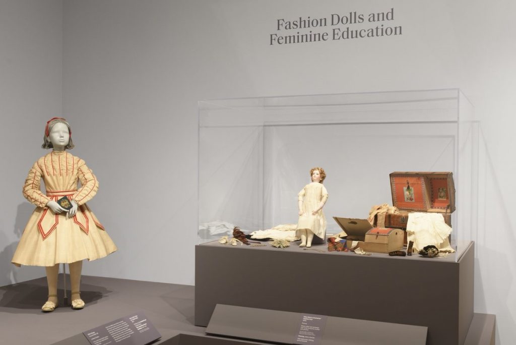 Exhibition display of dressed mannequin of a child and of dolls