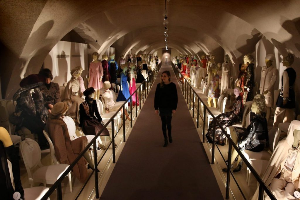 Exhibition display of dressed mannequins in a tunnel with path through the centre