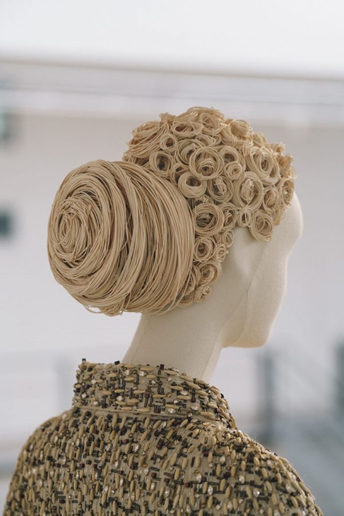 Exhibition display of mannequin with golden wig curled and in a bun