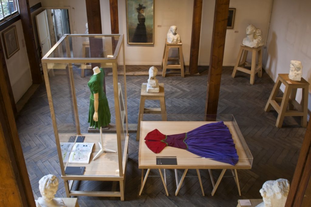 Exhibition display of dressed mannequins in case flat and upright in a case