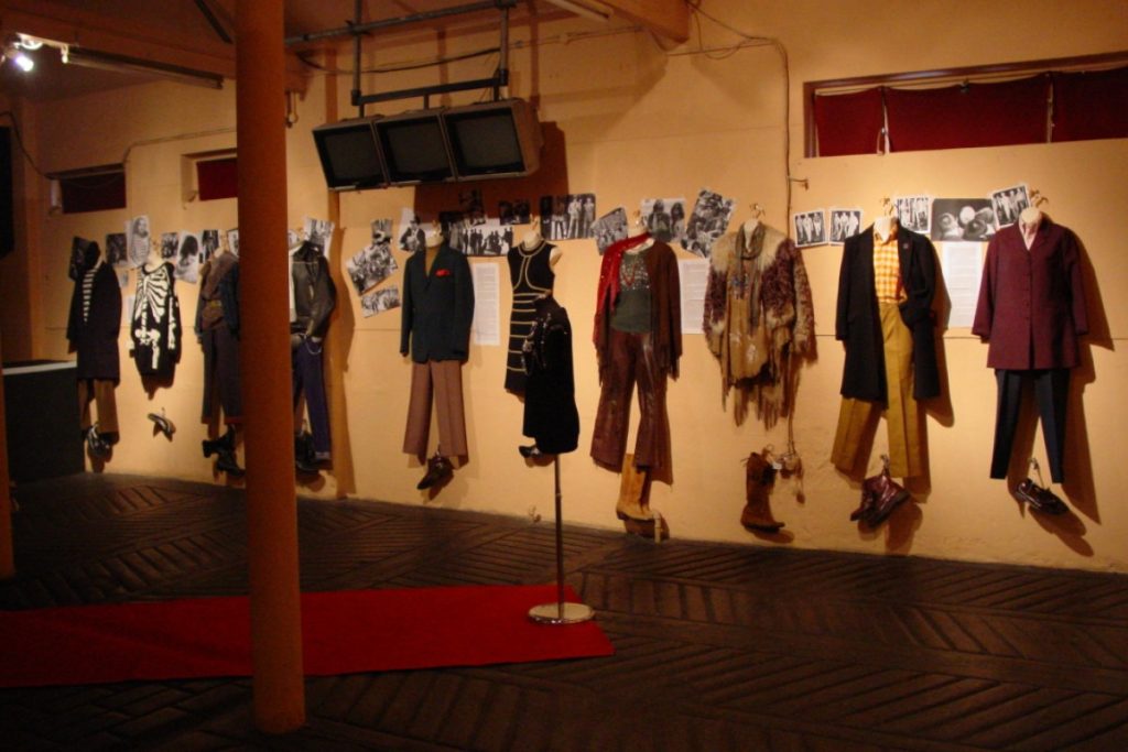 Exhibition display of dressed mannequins hanging on wall
