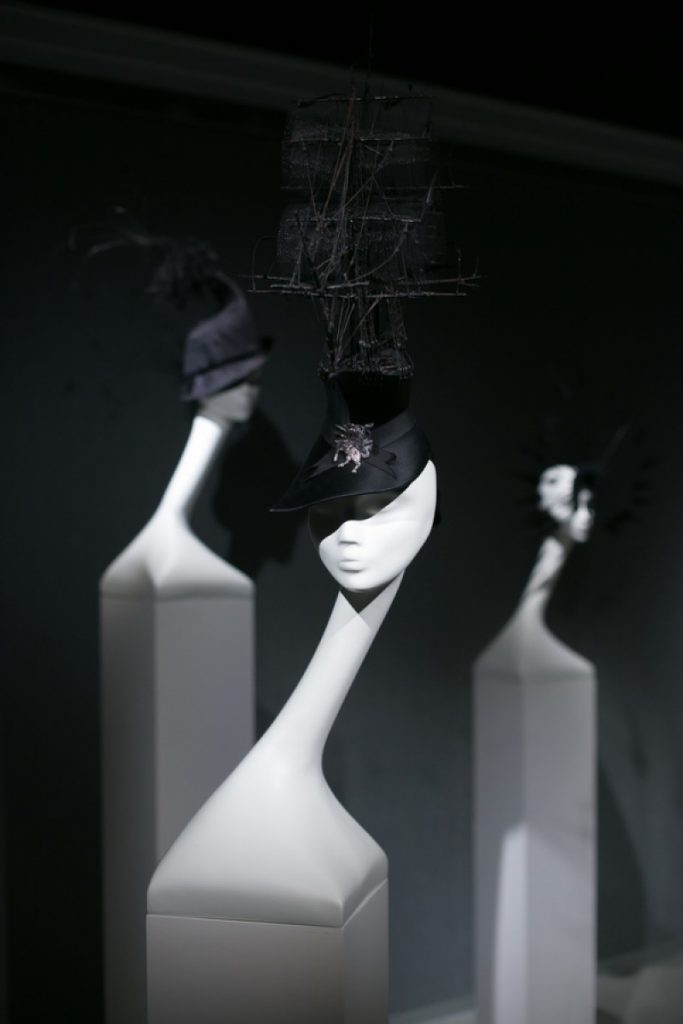 Exhibition display of mannequin heads wearing hats
