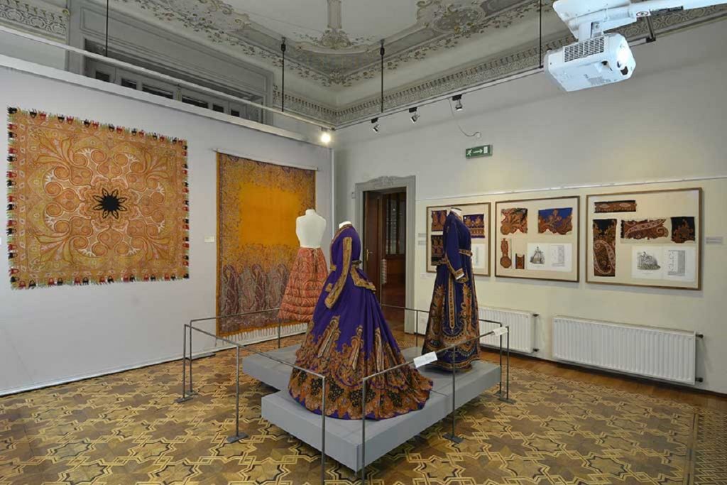 Exhibition display of dressed mannequins and textiles