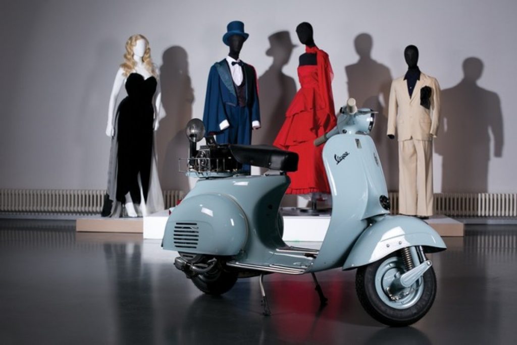 Exhibition display of Vespa scooter with dressed mannequins