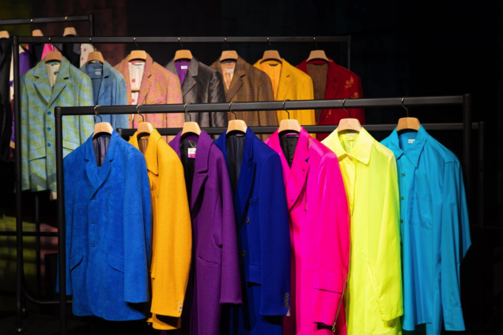 Exhibition display of coloured blazers hanging on rail