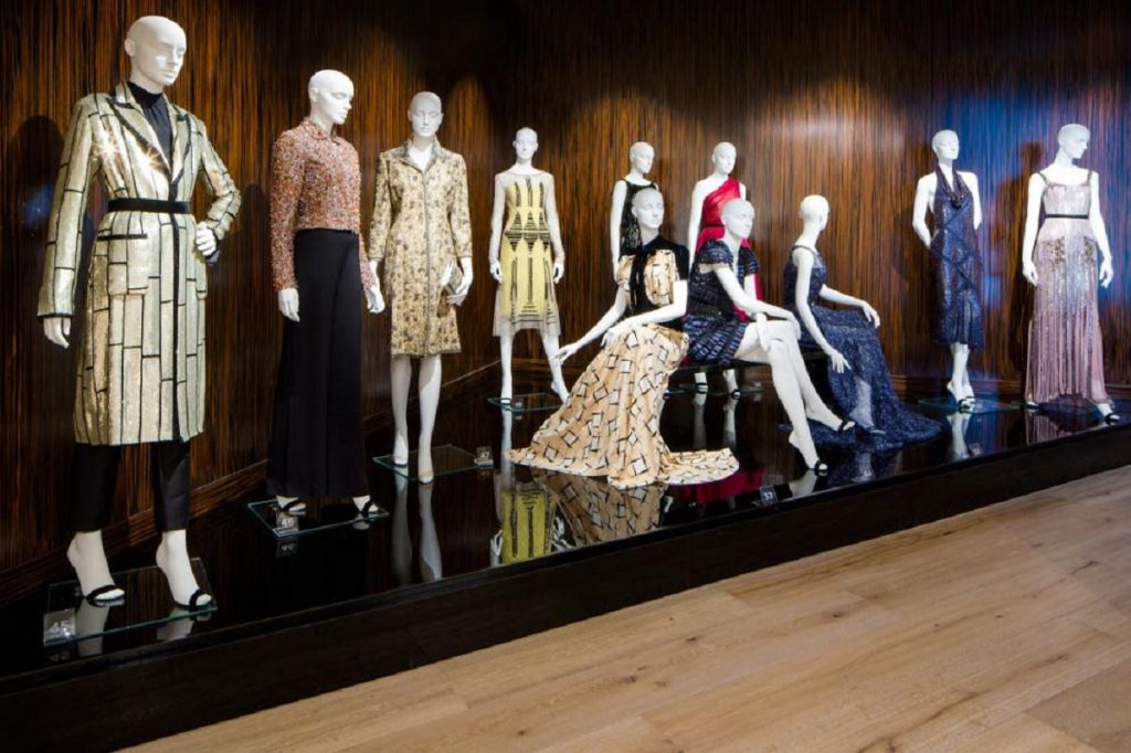 Exhibition display of dressed mannequins on a black plinth