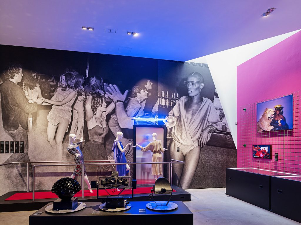 Exhibition display of dressed mannequins in a scene depicting entering a nightclub