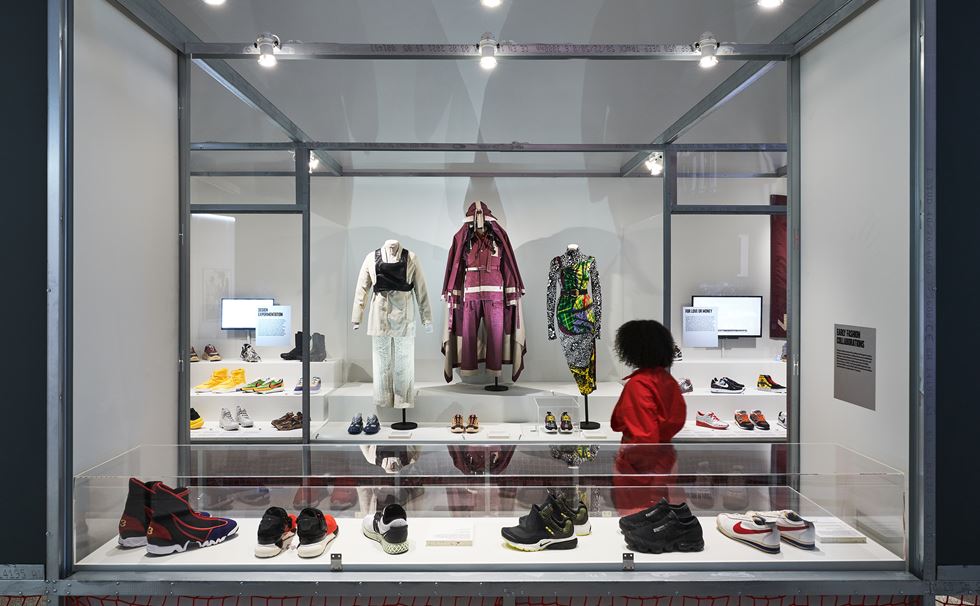 Exhibition display of trainers and sportswear with person viewing