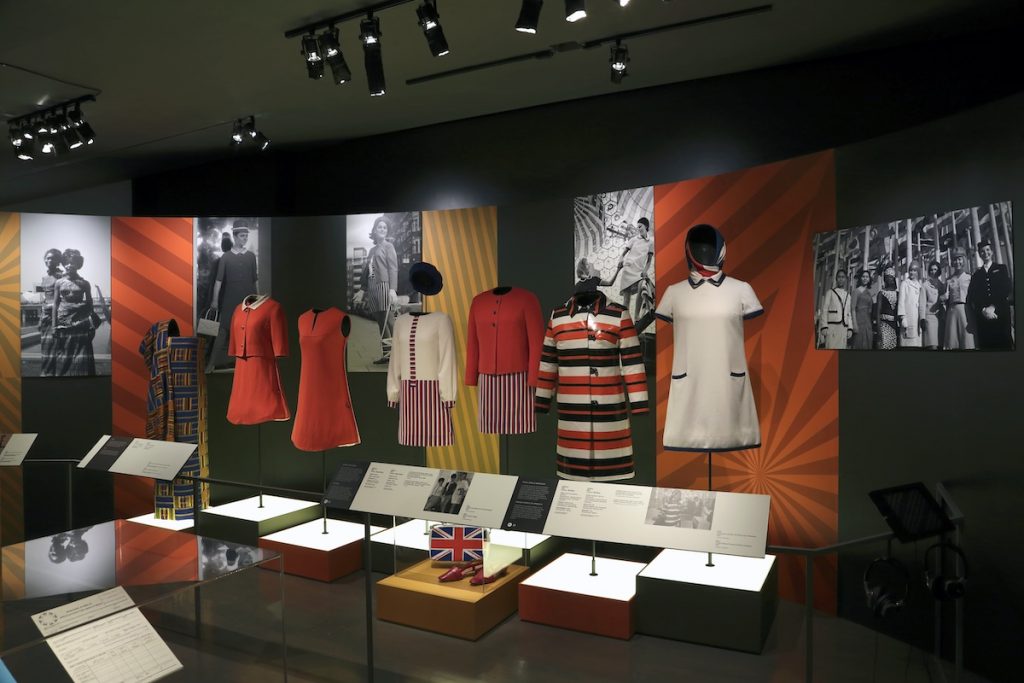 Exhibition display of 1960s short dresses with text panels in front of display