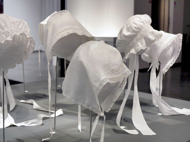 Exhibition display of white bonnets