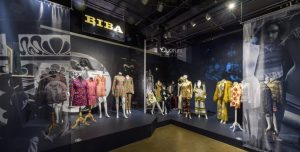 Display of colourful outfits on mannequins and busts. A BIBA sign han