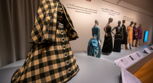 Exhibition displaying eight mannequins wearing garments from the 19th and 20th centuries.