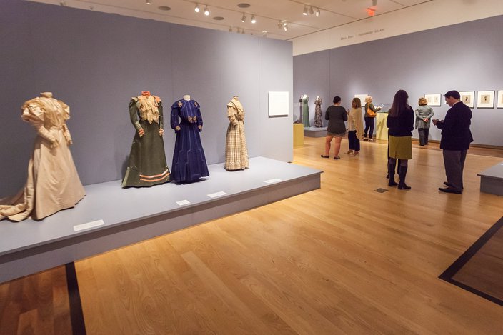 Exhibition with four mannequins displaying 20th century dress.