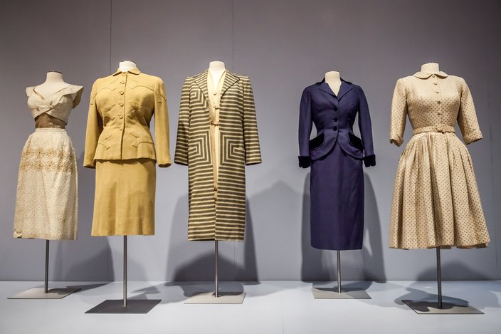 Exhibition with five mannequins displaying garments that span Garments that span 1945-55.