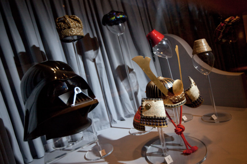 Exhibition with hats displayed in a glass cabinet.