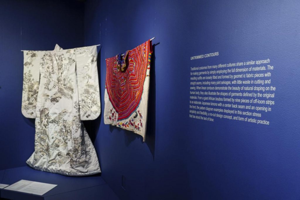 Exhibition displaying an African boubou and a Japanese kimono hanging from the wall.