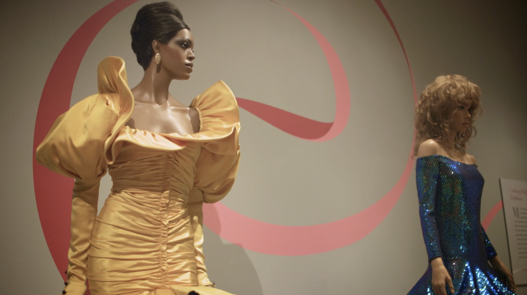 Exhibition with two mannequins; one a plus size mannequin displaying a dress.