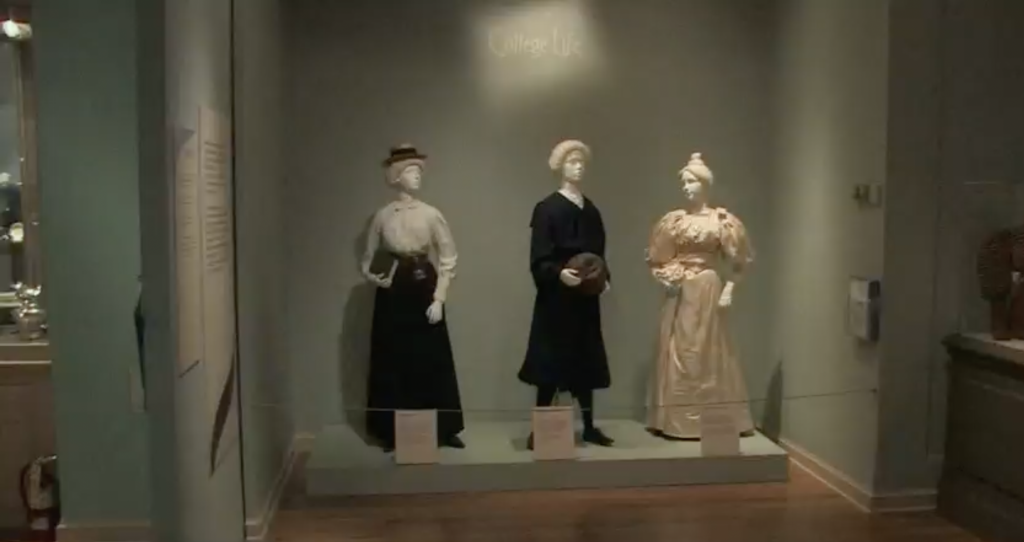 Exhibition with mannequins displaying garments.