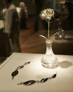 Exhibition with a glass cabinet displaying the "Ceylon Sinflower", a 400 carat yellow Ceylon sapphire mounted in 18 karat red gold that can be worn as a necklace, or detached and mounted on a flower stem.