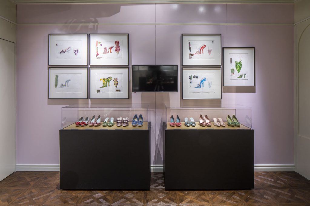 exhibition display of shoes in several glass cases in gallery