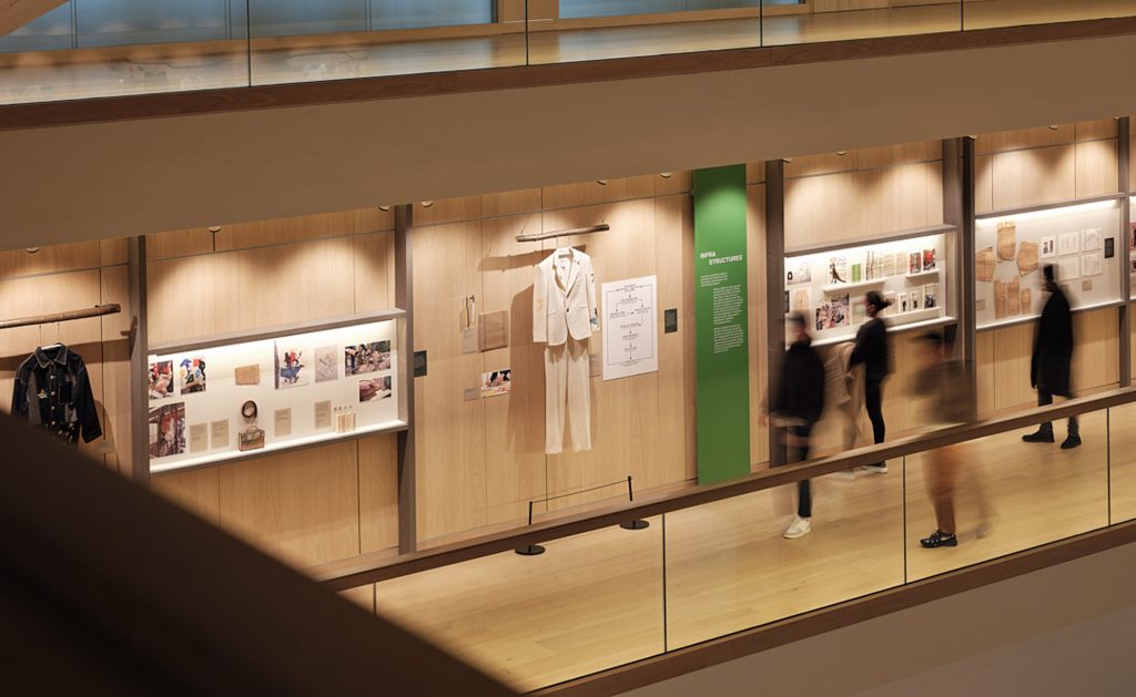 A view looking down at a display of a white outfit, photographs and green text panel
