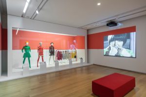 exhibition display of mannequins adjacent to a screen showing film of Mary Quant