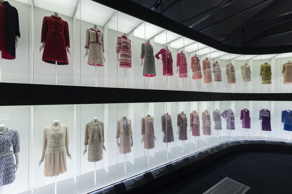 Two rows of Chanel outfits, categorised by colours against softly lit white backgrounds.