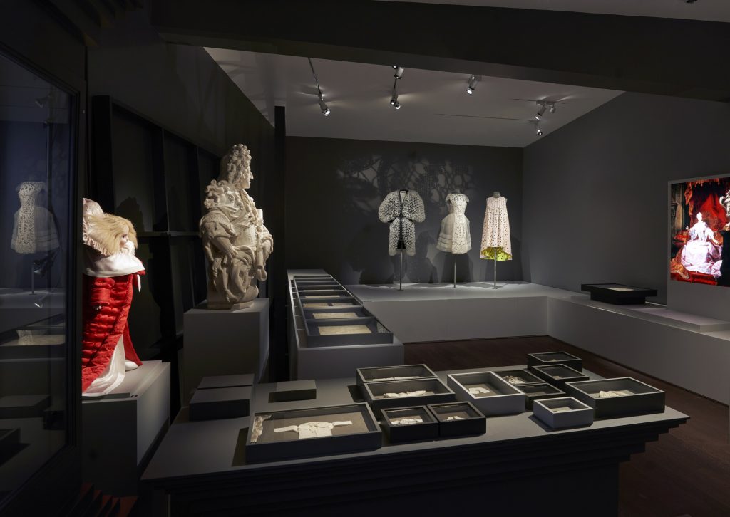 Gallery view showing three lace dresses displayed alongside boxes of 2D lace material; a doll and graphics.