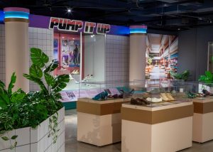 A gallery display with the phrase 'Pump It Up' in 80s-style font