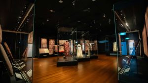 Gallery view showing dresses and textile samples.