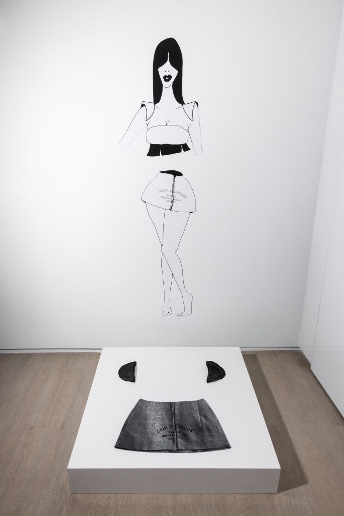 exhibition display illustration of woman cut in half at the waste with leather mini skirt on floor