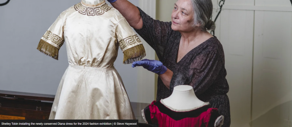Curator Shelley Tobin installing a garment onto a mannequin.