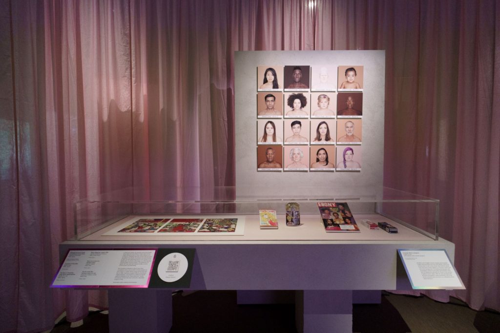 A display with pink background of photographs of different women and body types.