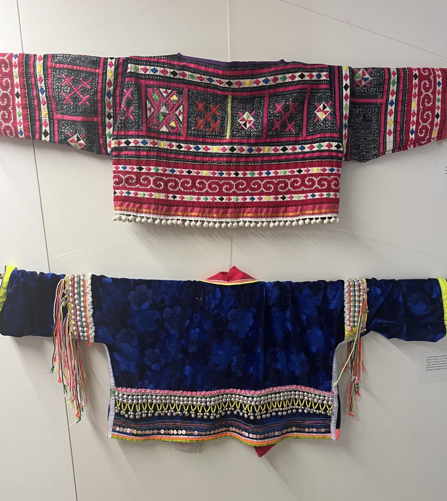 Two woven jackets on a display wall. 1 red woven pattern and a blue women pattern.