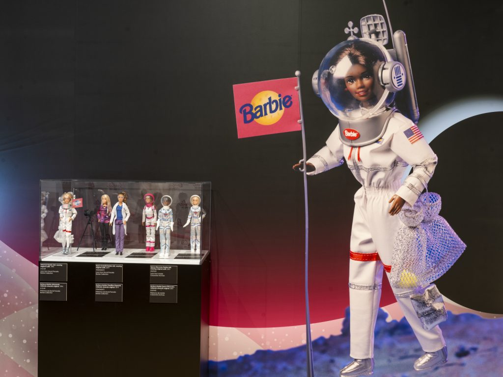 A display of Barbie in Space fashion. The dolls wear suits in White and blue.