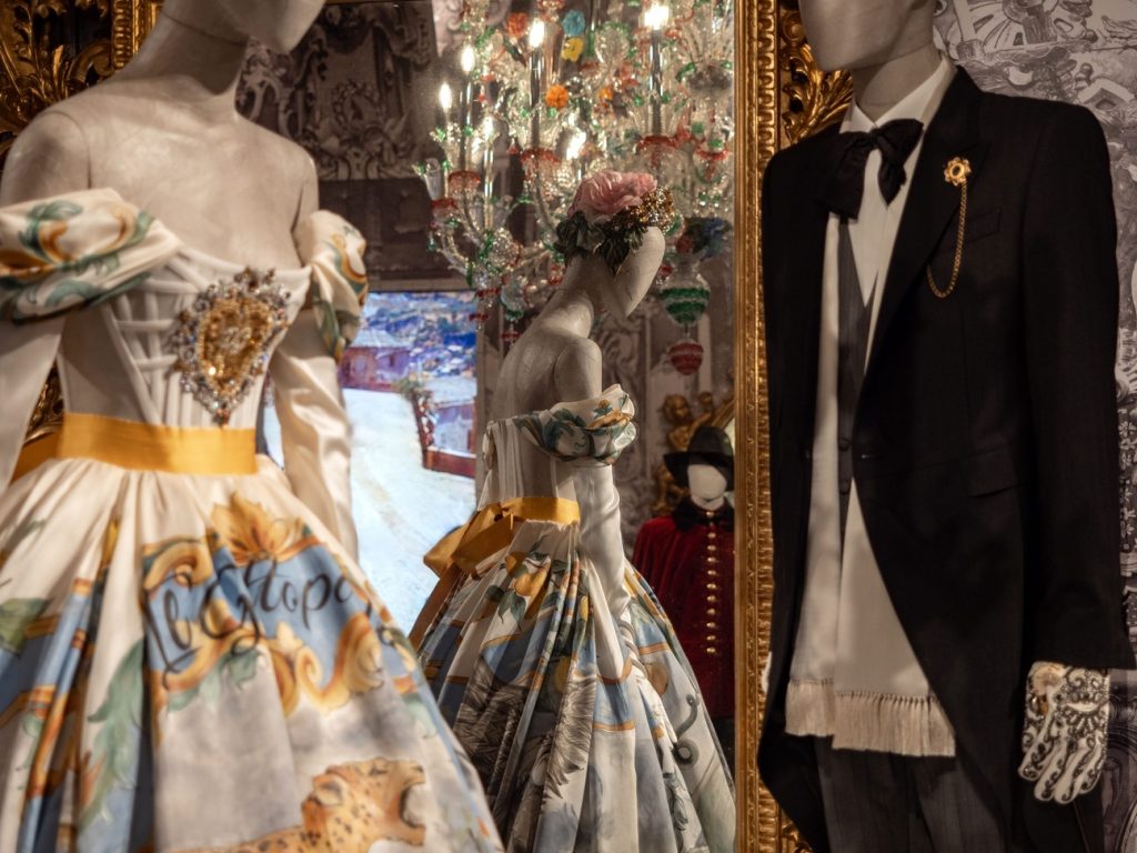 Female and male mannequin dressed for ballroom. Male is dressed in black and white tuxedo and female in a white and yellow dress