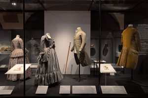 The Palais Galliera traces the history of fashion from the 18th century to the present. Male and female grey 18th century clothes.