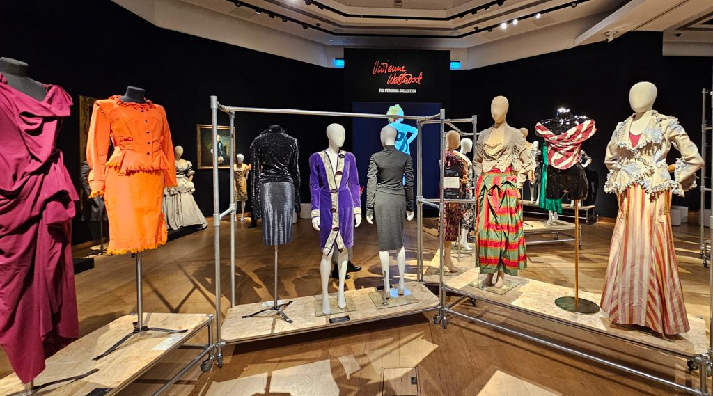 A display of colourful mannequins wearing Vivienne Westwood garments in hues of orange, pink, blue and red.