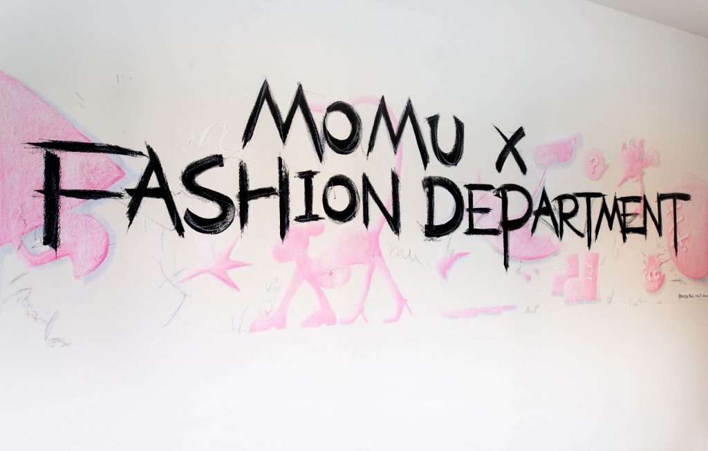 MOMU X Fashion Department pink and black sign.