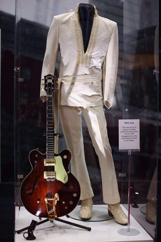 Mannequin dressed in the iconic white Elvis suit and posed with a guitar.